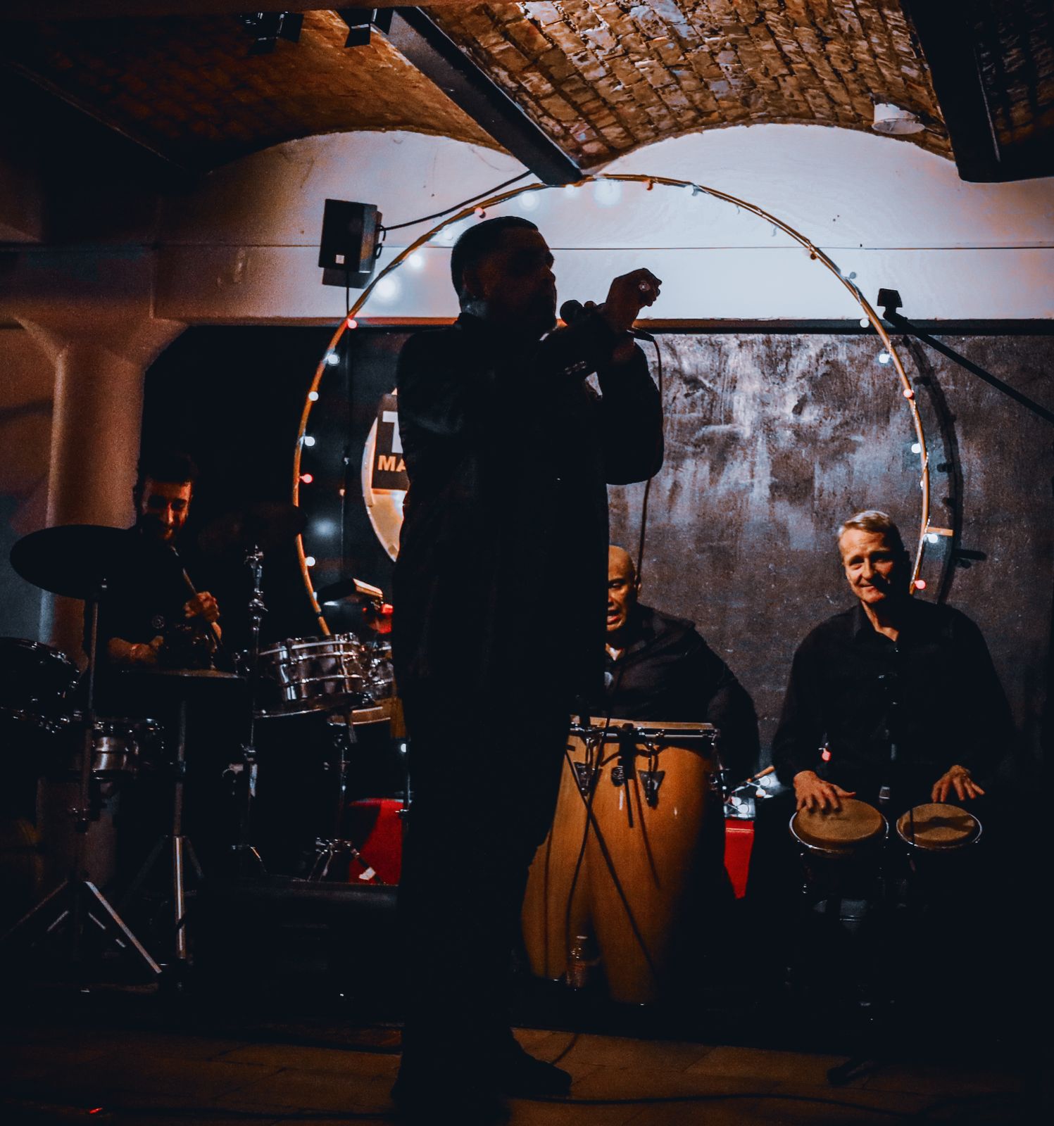 JL Son de Armonía live — vocalist at the mic with congas and timbales behind him